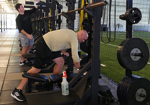 Image of strength and conditioning coaches Cody Ellett (foreground) and Cole Moos will be sanitizing equipment regularly as workouts begin Monday for BA athletes.